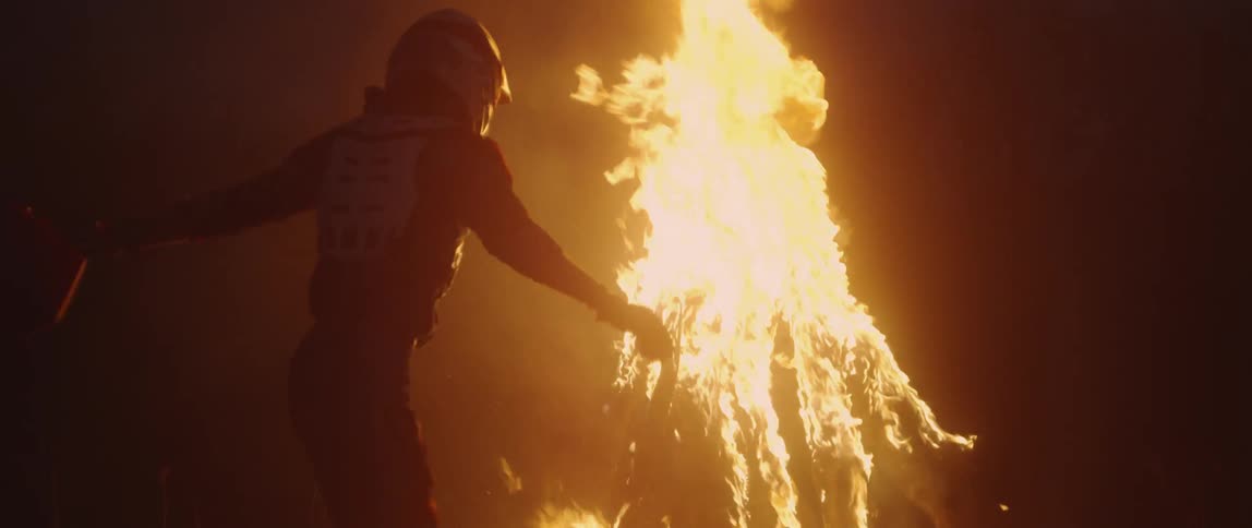 A man pours gasoline on a fire