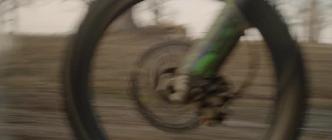 Person rides a dirt bike through the woods