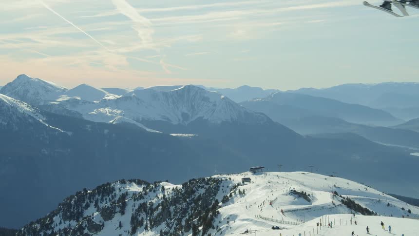 Skiers glide down a snowy mountainside