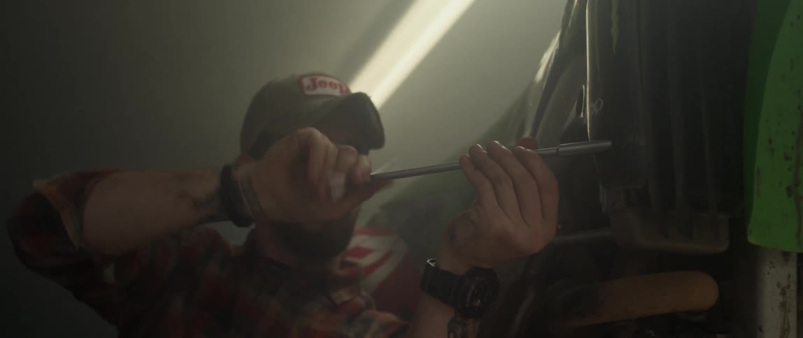 A man uses a tool in a garage