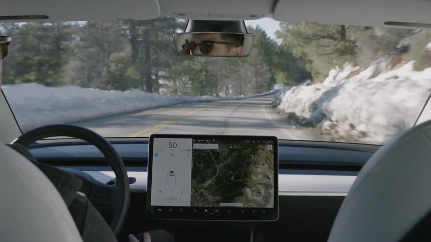 A man drives a vehicle on a snowy mountain road