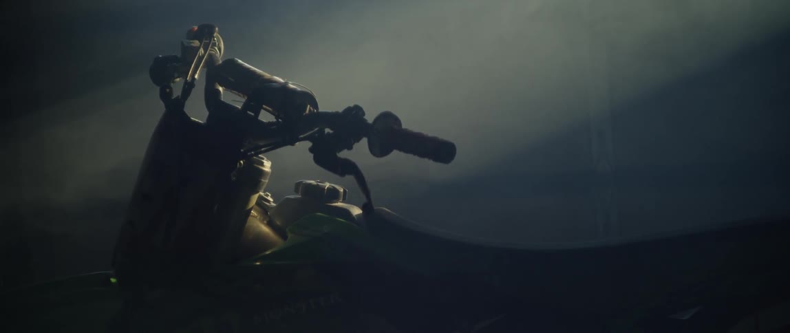 A dirt bike sits parked in a dusty garage
