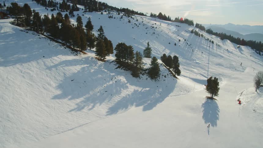 Skiers are skiing down ski slopes on a sunny day