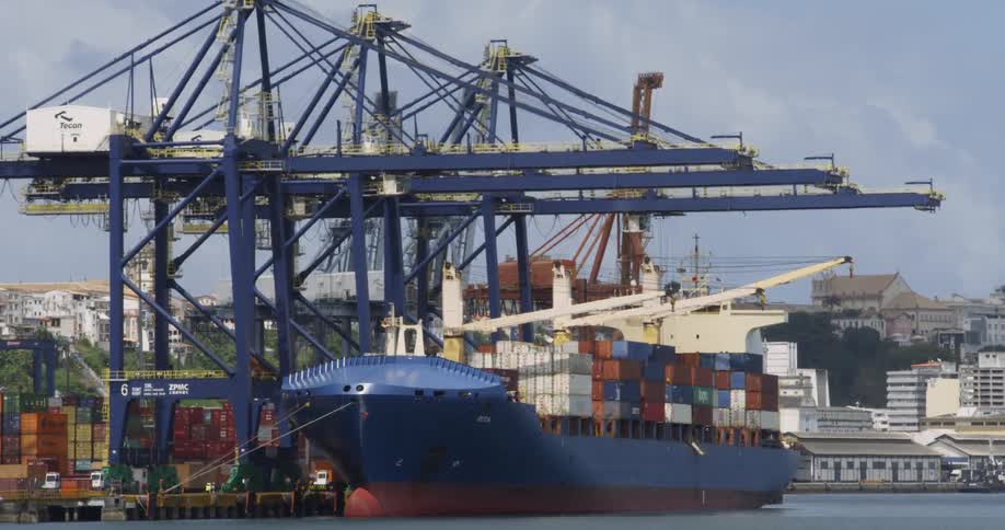 Large cargo ship full of shipping containers sits at dock