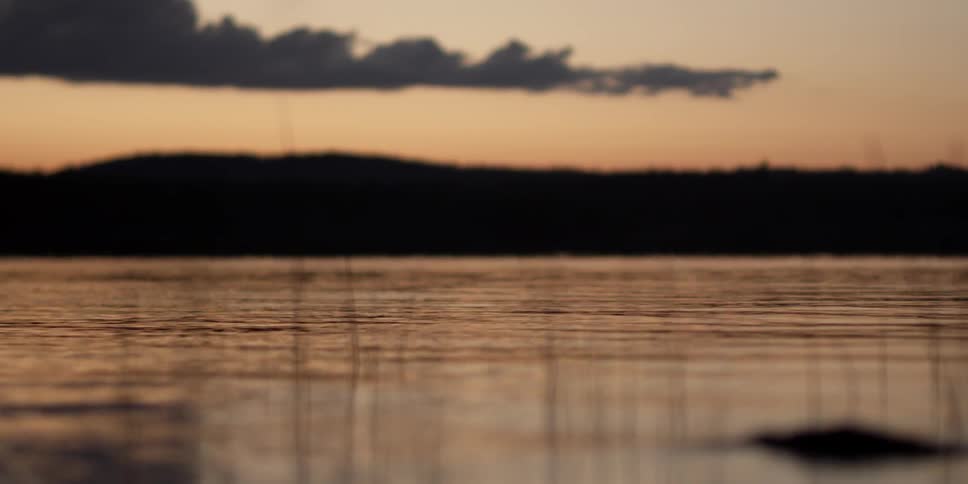 Calm waters rippling at a partly cloudy sunset
