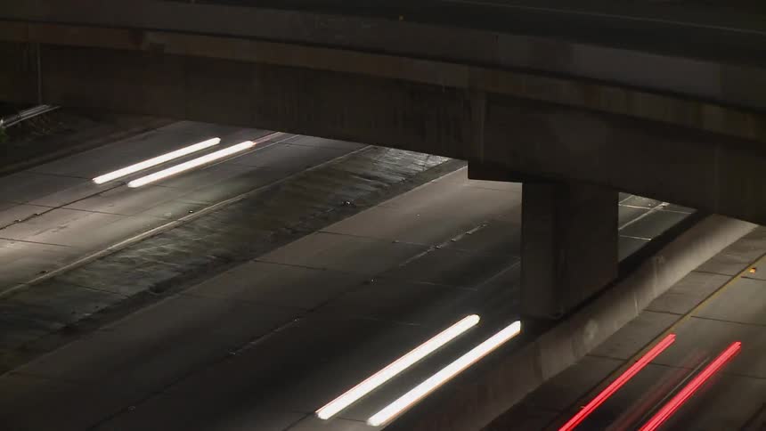 Time lapse of traffic passing under an overpass at night