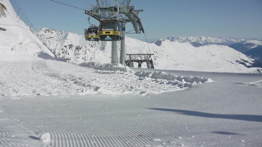 Gondola running on snow covered mountain ski park on sunny day