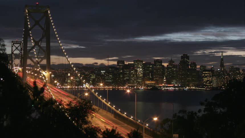 Cars cross a city bridge at night