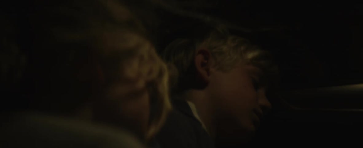 Two children sleep in the back of a car
