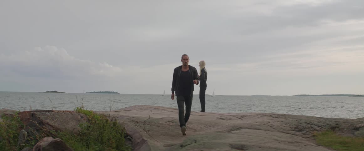 A distressed couple separates after a heated relationship conflict next to the sea.