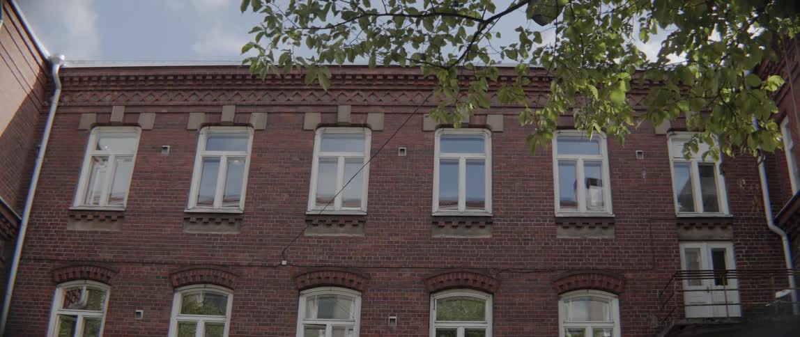 Detailed brickwork frames the windows of a quiet city residential structure outside.