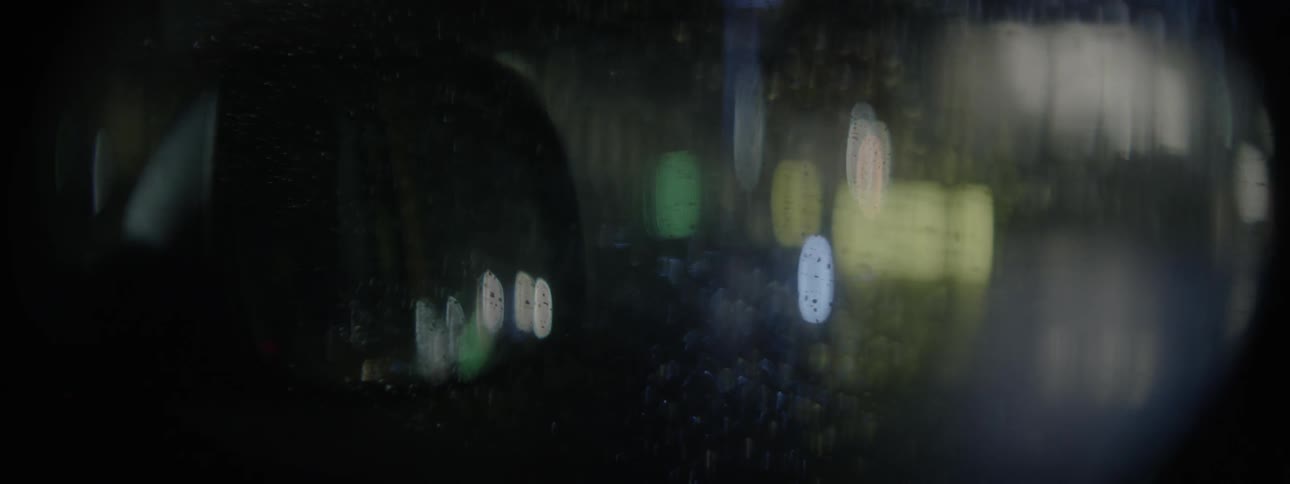 Lights reflect on a wet car window