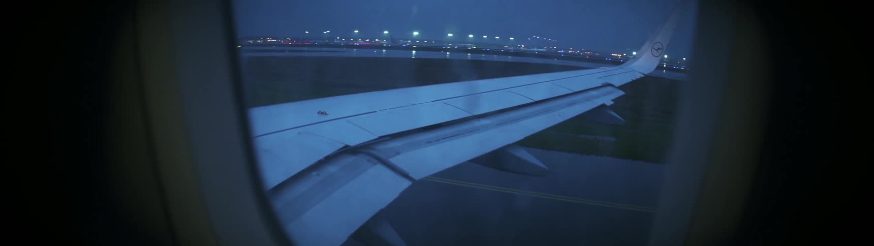 The rain is pouring on the plane as it moves on the runway