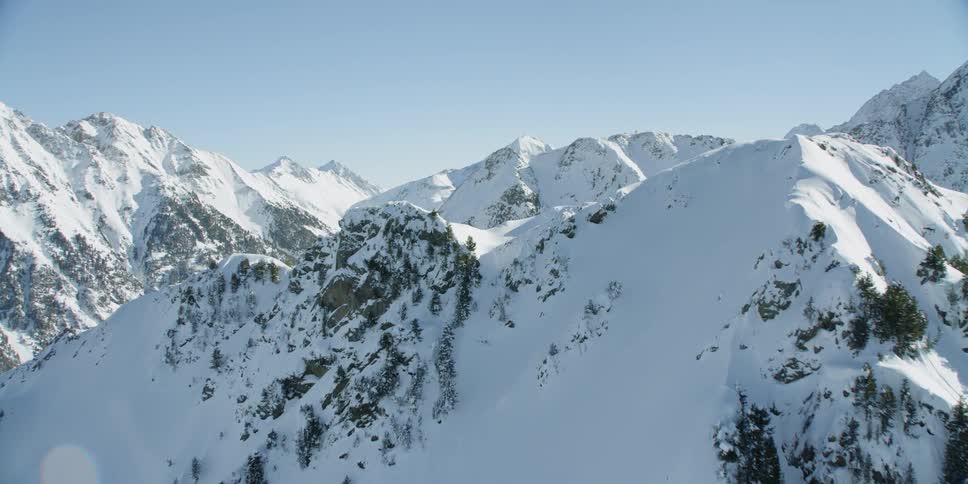 Snow is covering the slopes of a mountain range during the day