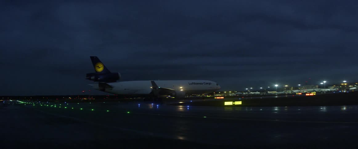 Large airplane sitting on runway of airport at night