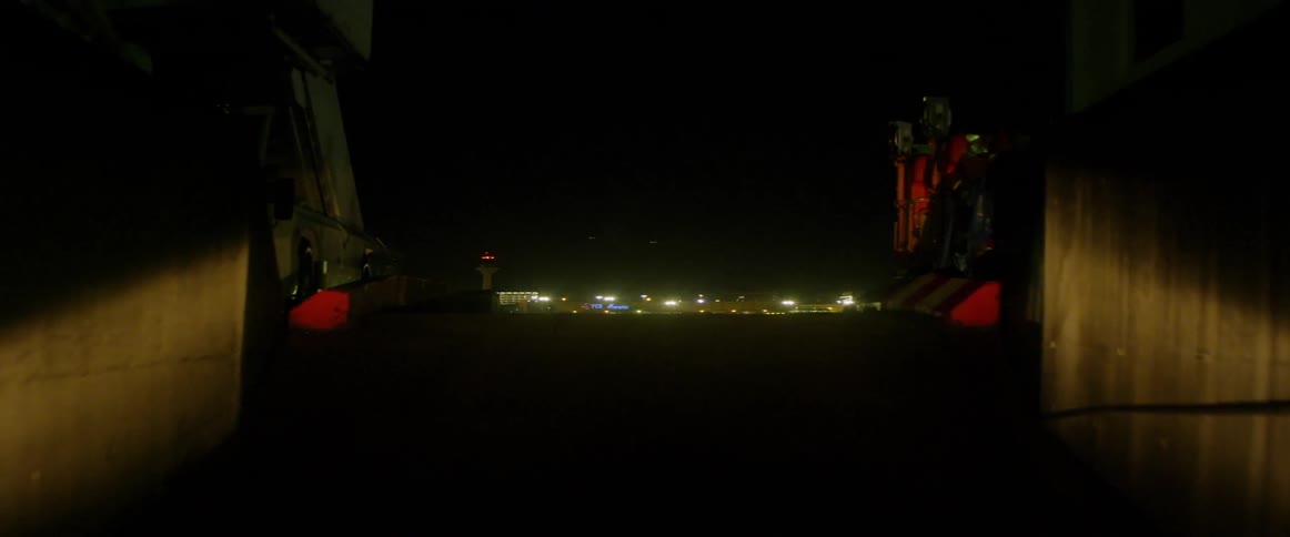 Moving through a tunnel out onto the tarmac at night