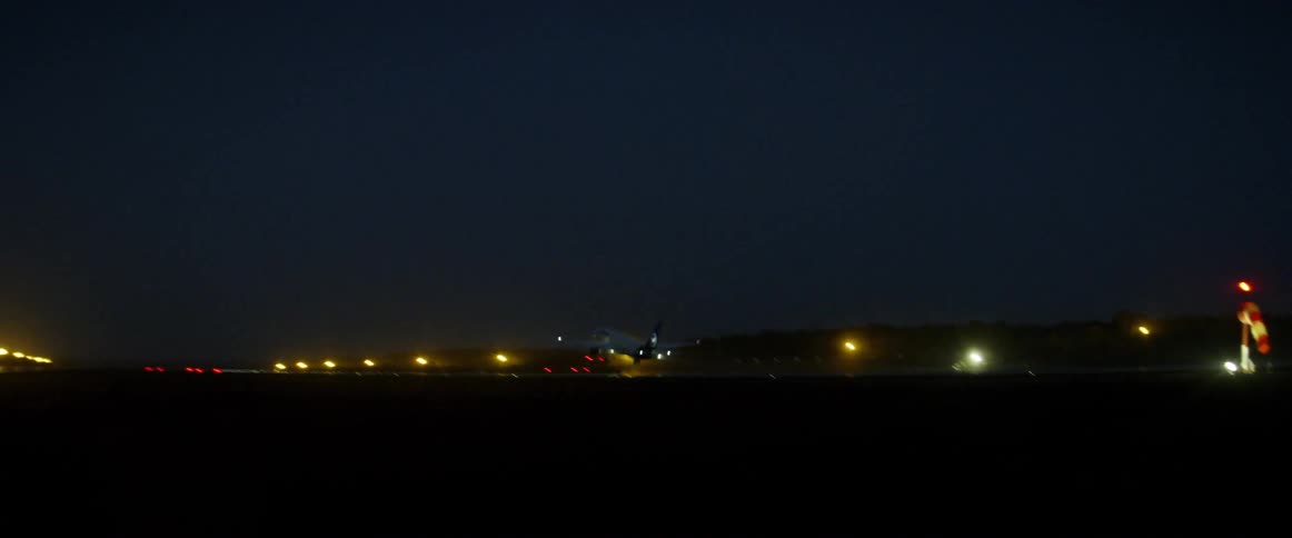 Airplane lifting off of runway at airport at night