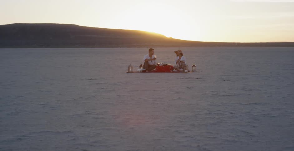 People having a picnic in a very barren area at sunset