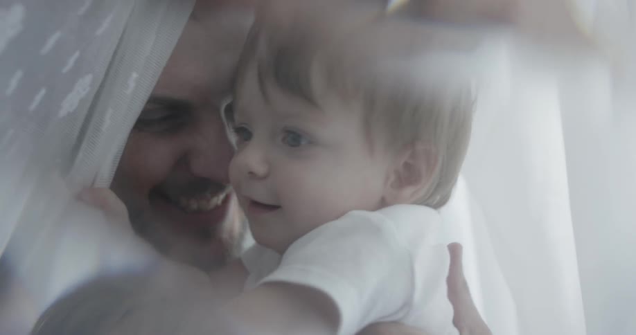 A man and child are in the bed playing