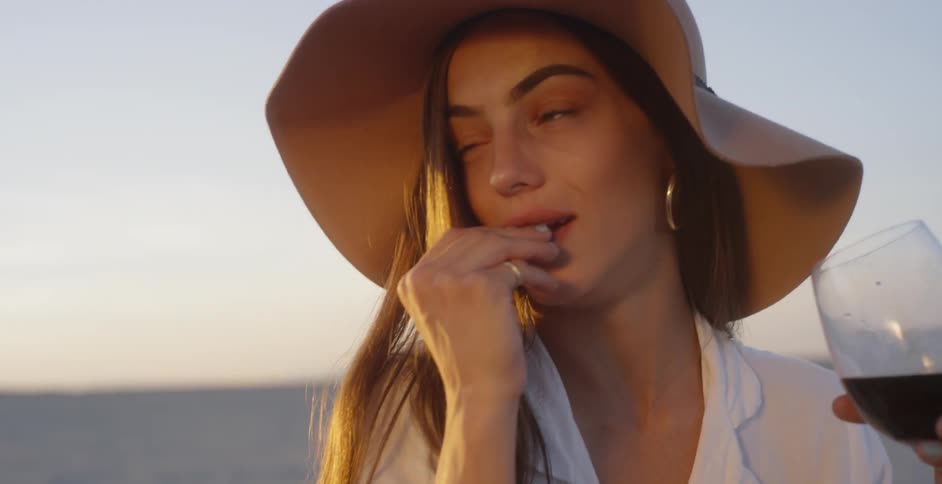 A woman picnics in a desert at sunset