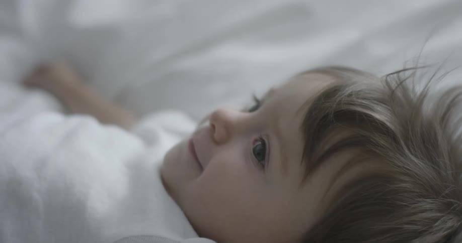 A baby smiles as his father kisses his feet