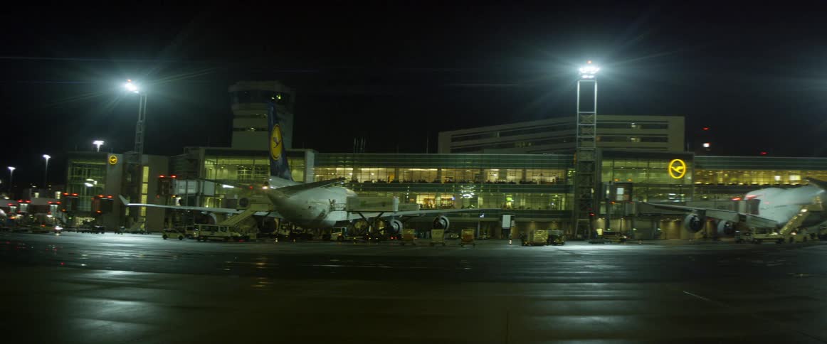 Airplane sitting at terminal in airport at night