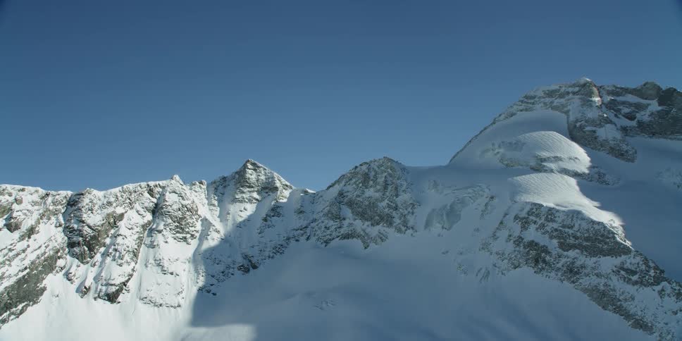 Sun shines down over snow covered mountains