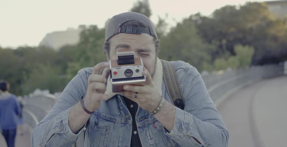 A man takes a photograph on the walkway