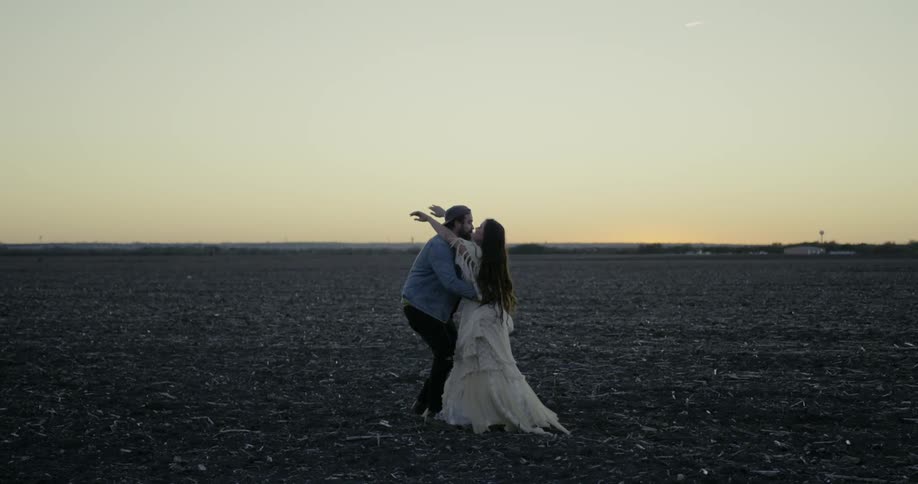 A man and woman embrace on the field