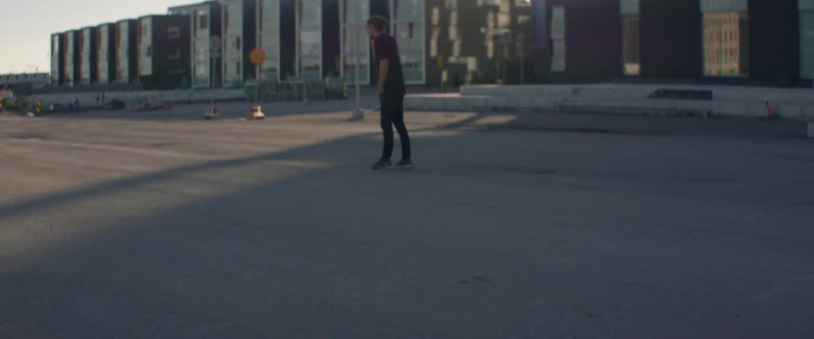 A man walks outside a group of buildings talking on his phone