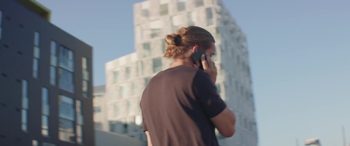 A man walks outside while using a phone