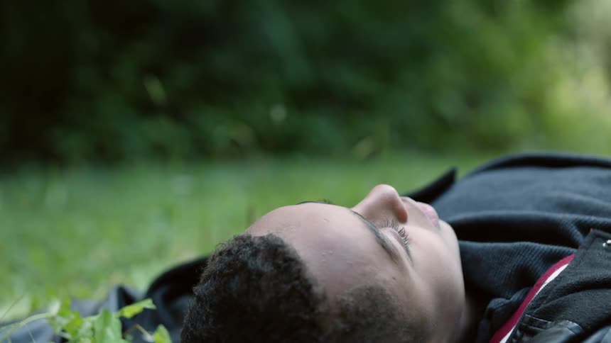 A boy lies in the grass