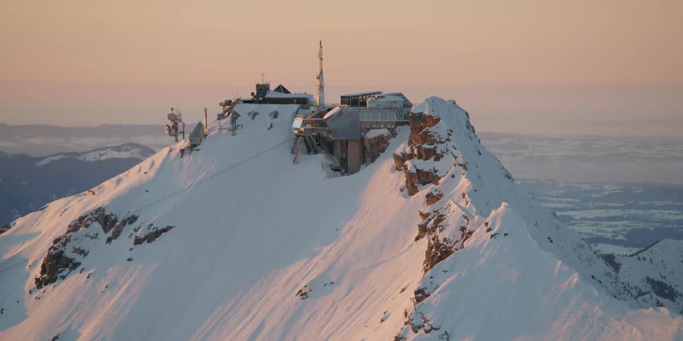 A large building is built onto a large snowy mountain
