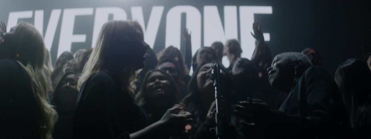A choir sings on a stage with flashing lights