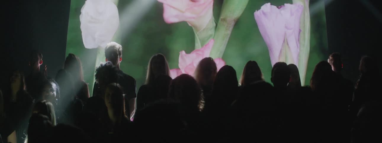 A projection plays behind a singing choir