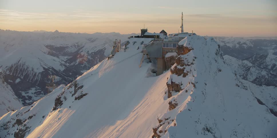 A large building is built onto a large snowy mountain