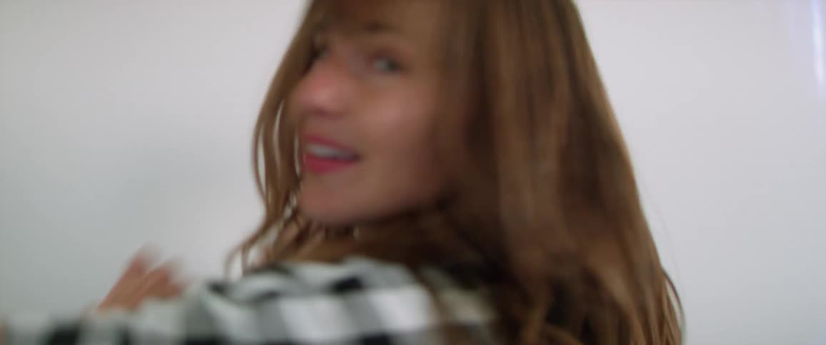 A woman sways her hair back and forth and dances