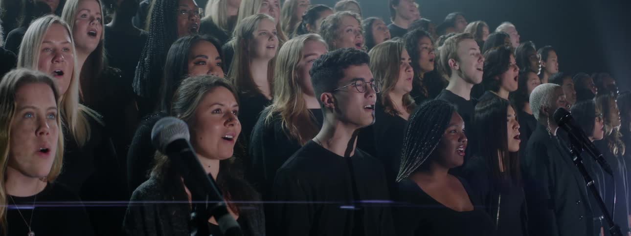 A projection is displayed on a singing choir