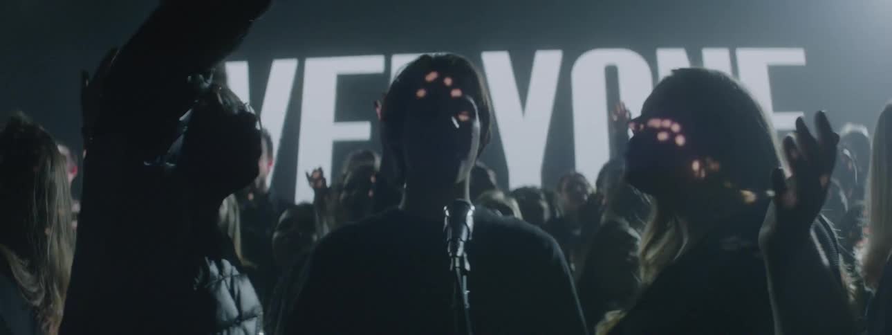 A choir sings on a stage with flashing lights