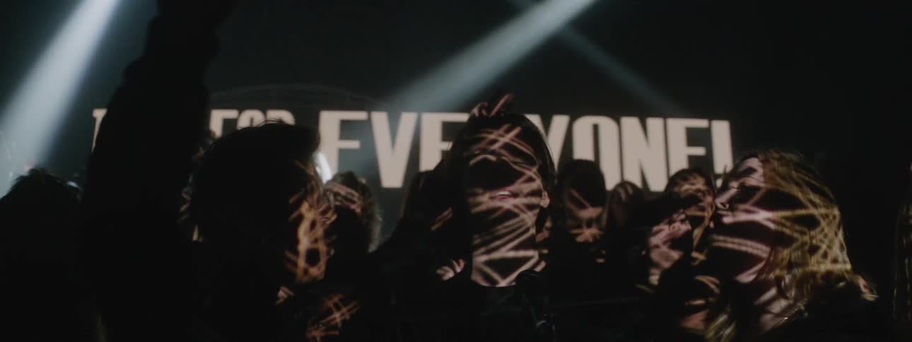 A choir sings in a room with flashing lights