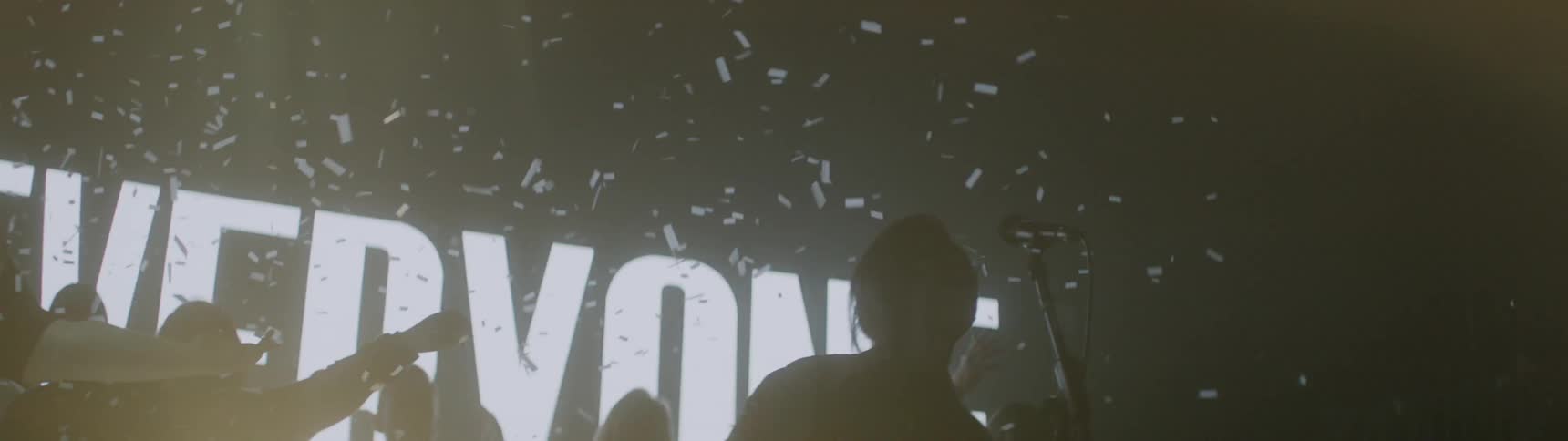 Confetti falls on singers while lights flash