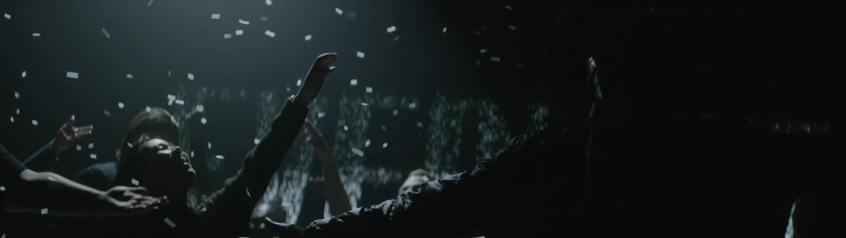 Confetti falls on singers as lights behind them flash and change