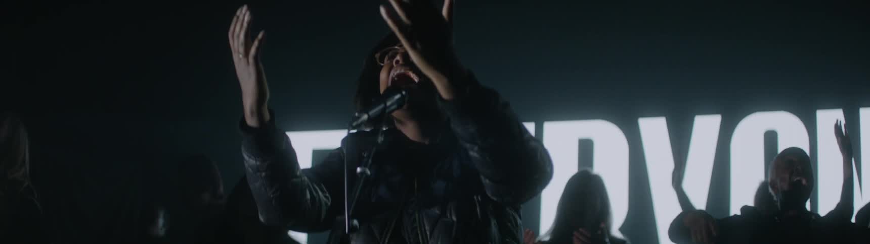A choir performs in a dark room