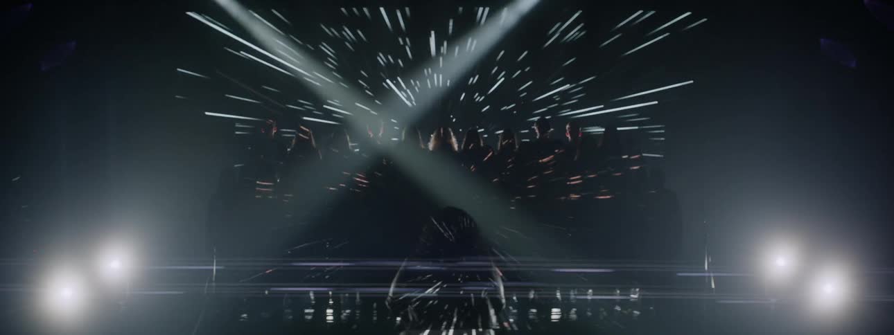 Woman is orchestrating a choir in front of television screen in dark room