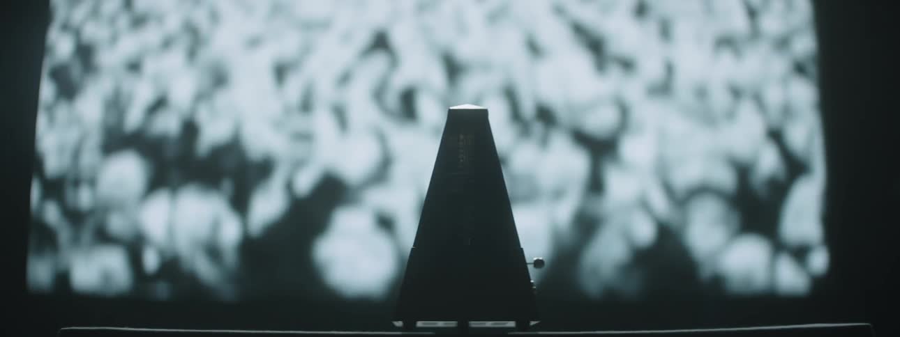 A metronome ticks by a projection