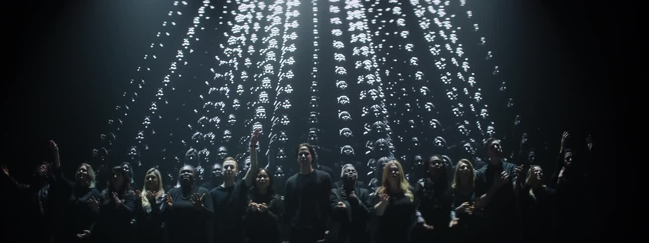 A projection plays behind a singing choir
