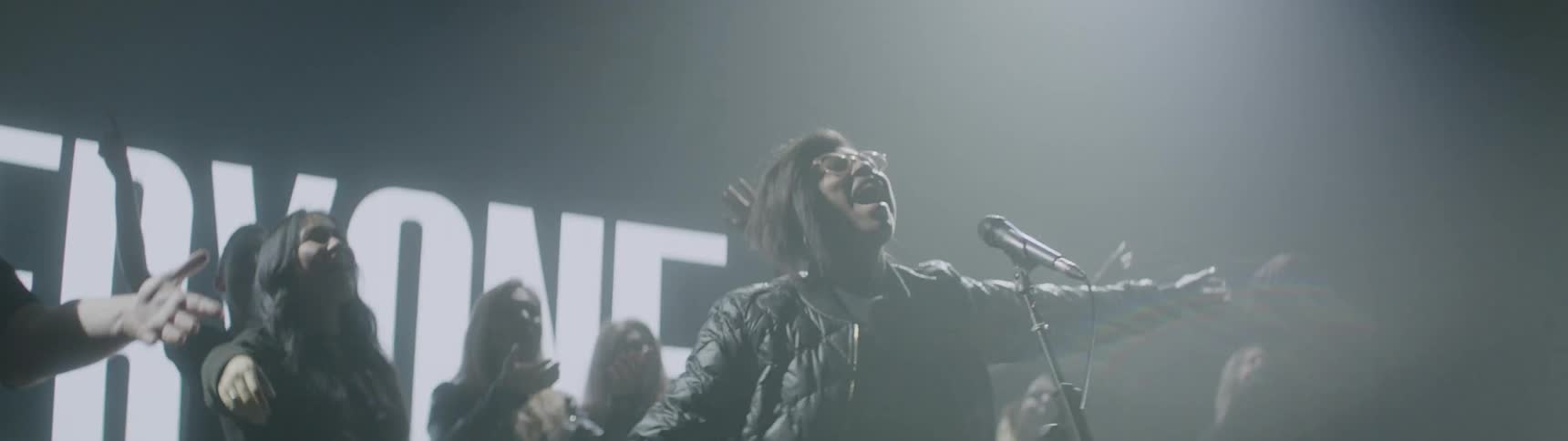 A choir performs in a room with flashing lights