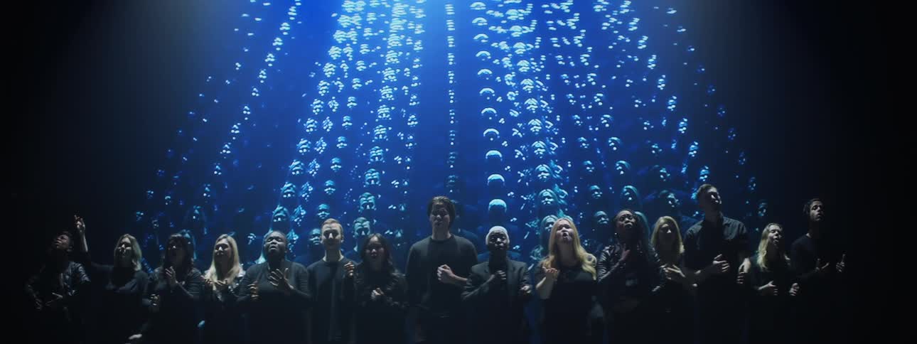 A choir motions with their hands while singing