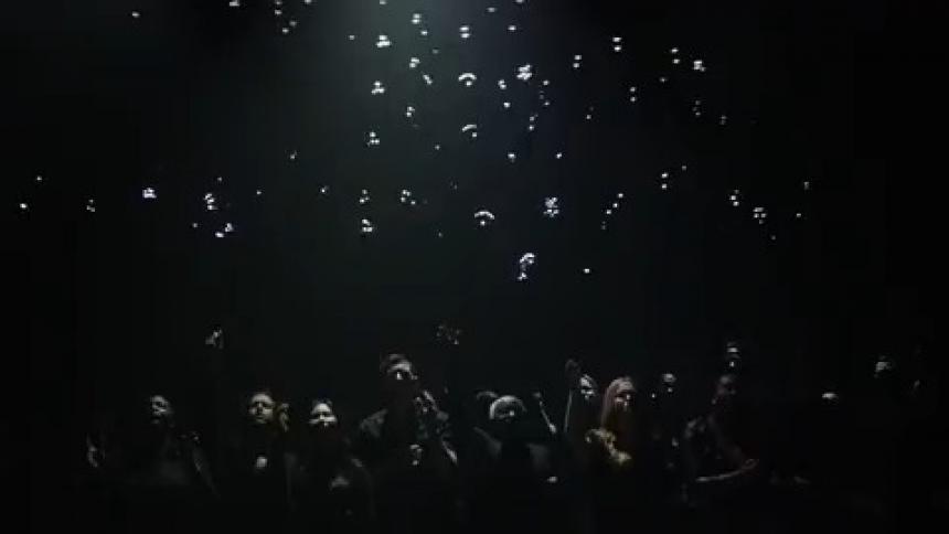 The strobe lights flash on the audience