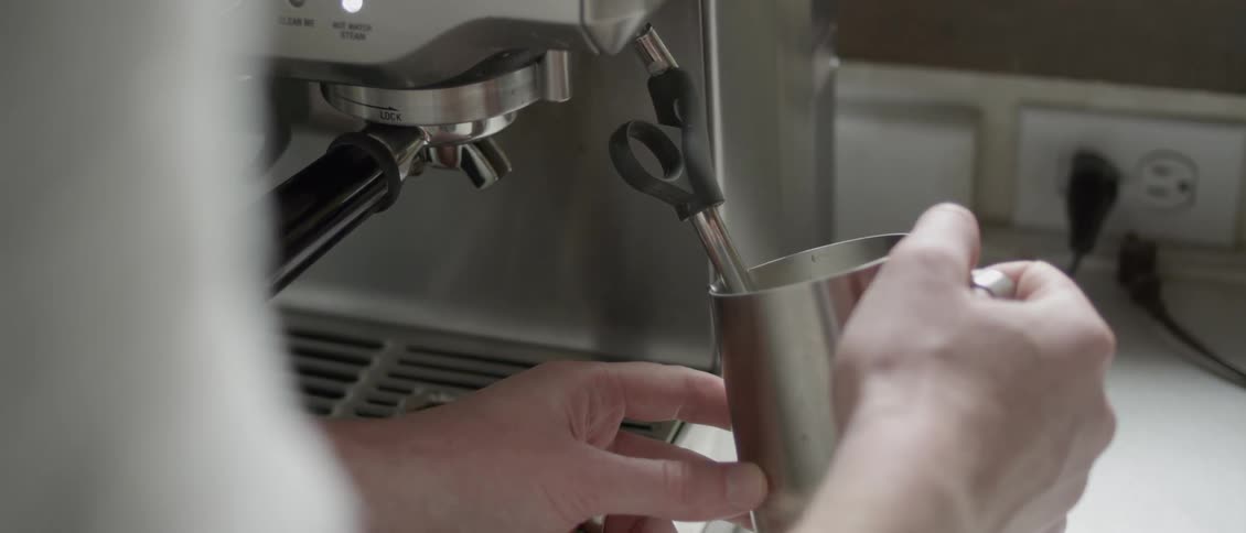 A person makes a cappuccino